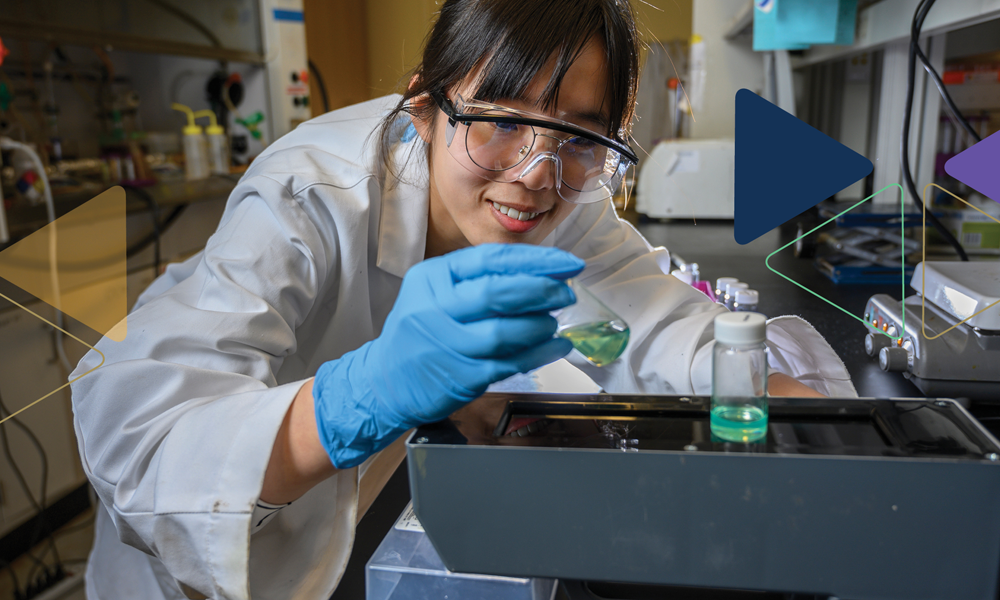 Georgia Tech researcher examines liquid vials in a laboratory.